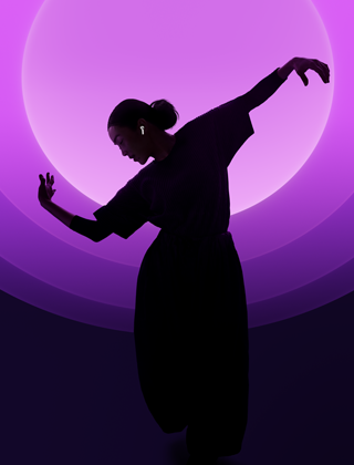 A person dancing while wearing AirPods 5, multi-coloured background